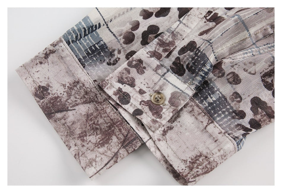 Close-up of a printed sleeve cuff with a small tan button and visible stitching.
