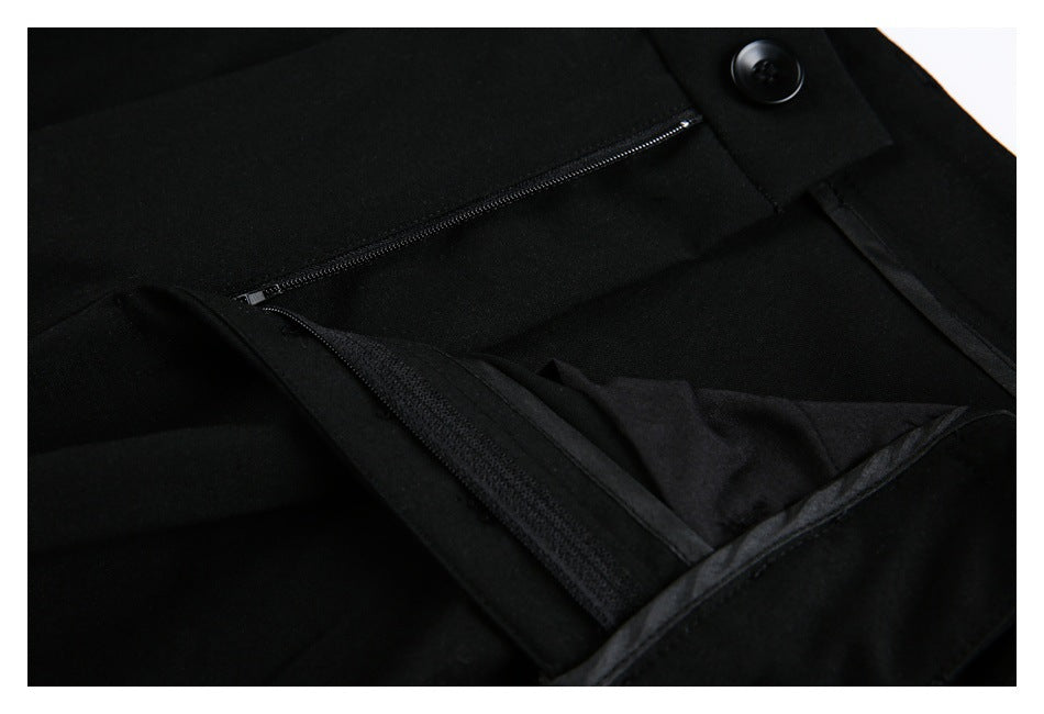 Close-up of black trousers with the fly open, exposing a zipper and inner fastening.