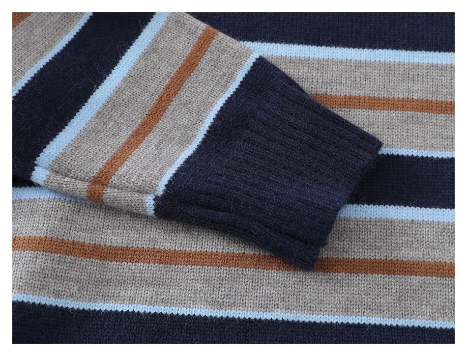 Close-up of a sweater sleeve and ribbed navy cuff against gray, navy, pale blue, and rust stripes.