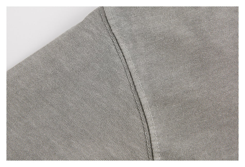 Close-up of a diagonal stitched seam on gray knit fabric.