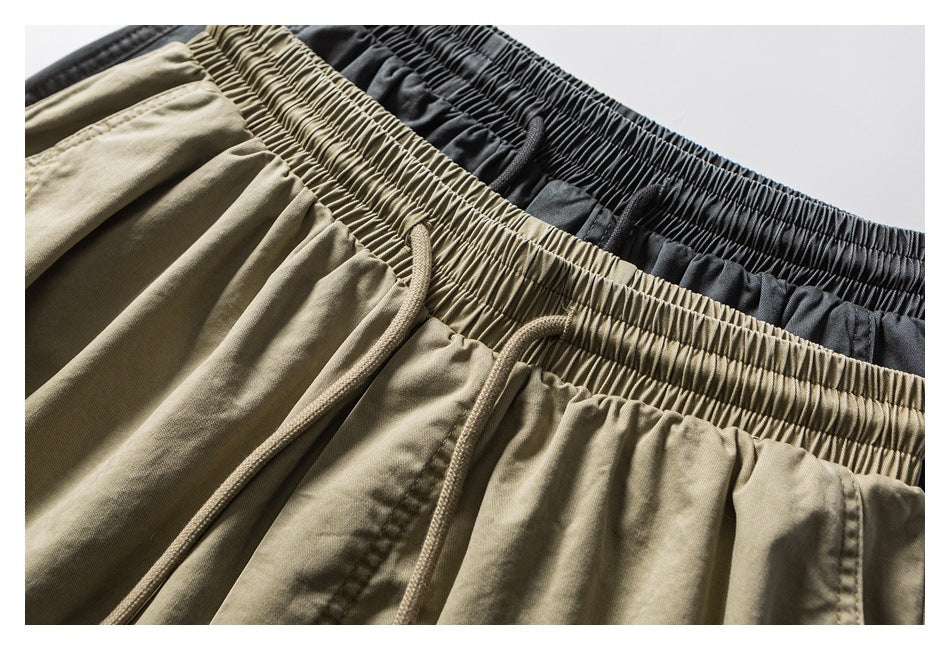 Close-up of khaki and charcoal shorts showing gathered elastic waistbands and matching drawstrings.