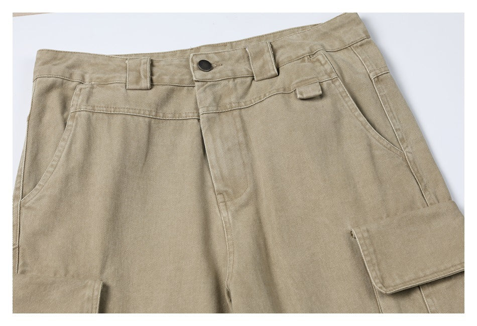 Close-up of light khaki cargo pants showing the buttoned waistband, belt loops, front pockets, and cargo pocket flap.