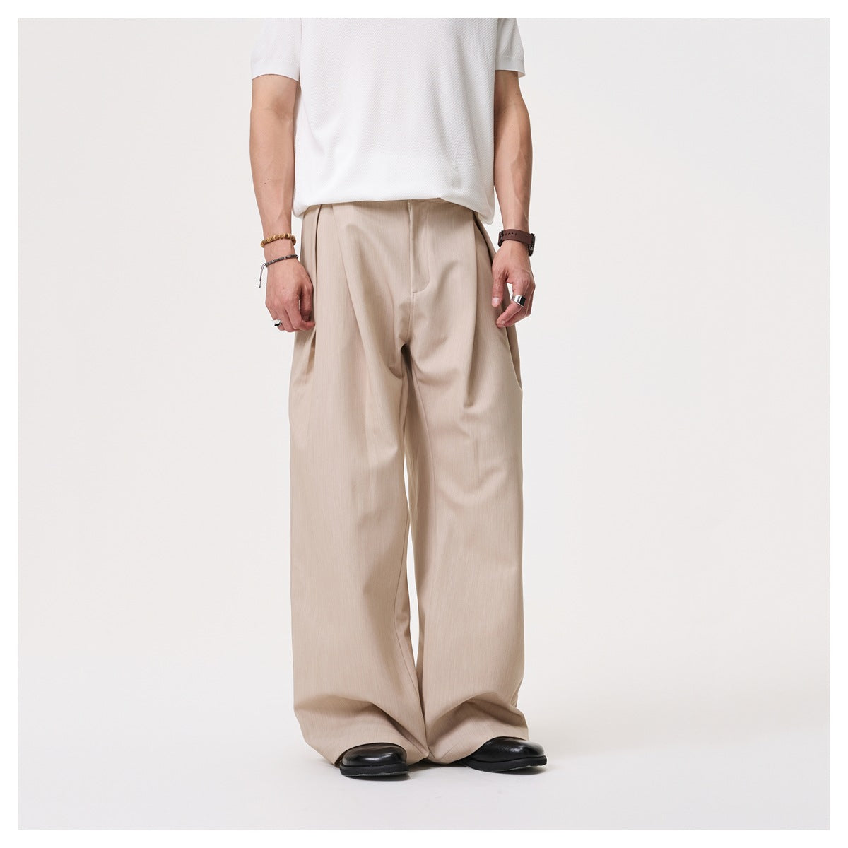 Cropped model wearing beige wide-leg trousers with a white shirt, shown from the front.