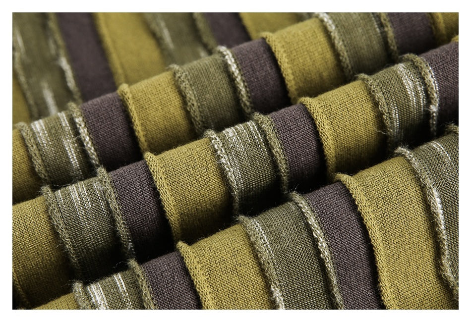Macro view of folded olive, brown, and textured green striped fabric with raised stitched edges.