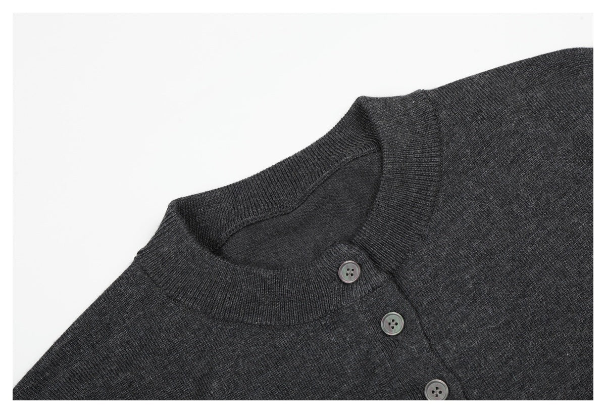 Close-up of a charcoal knit top's ribbed round neckline and angled button placket.
