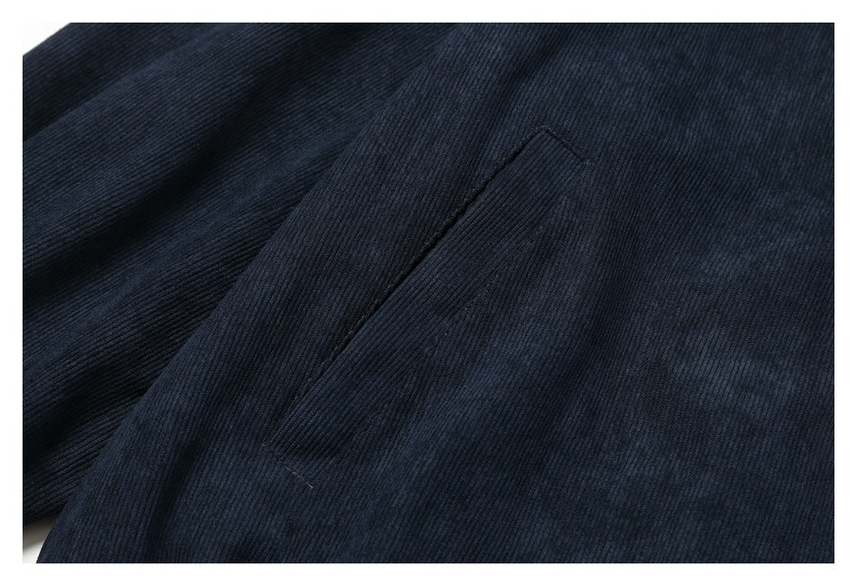 Close-up of a narrow welt pocket on dark navy ribbed fabric.