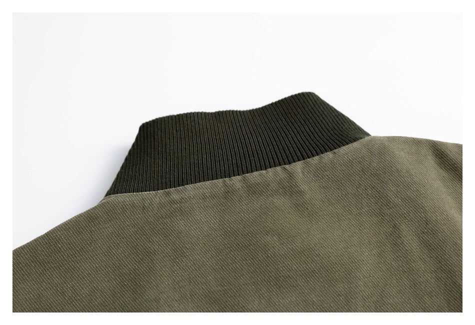 Close-up of an olive-green garment beside a dark ribbed collar.