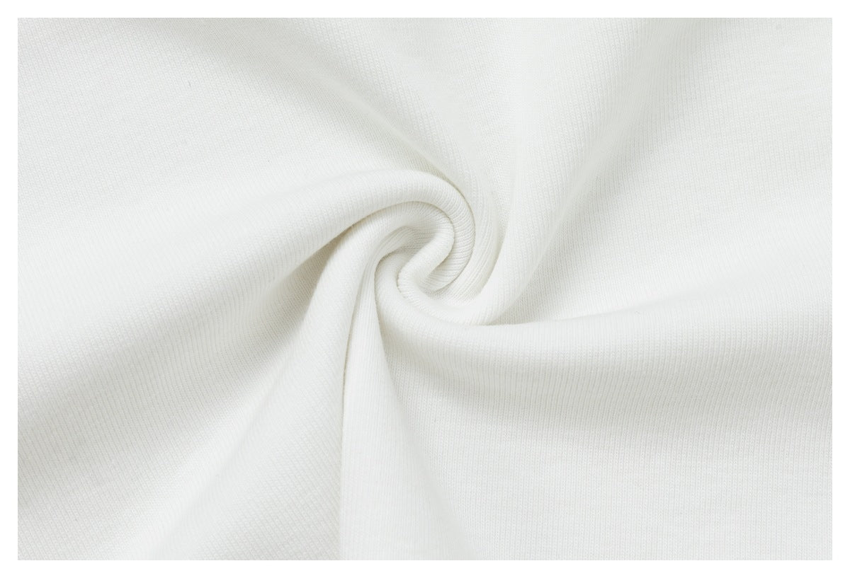 Close-up of white knit fabric twisted into a spiral to show its texture and drape.