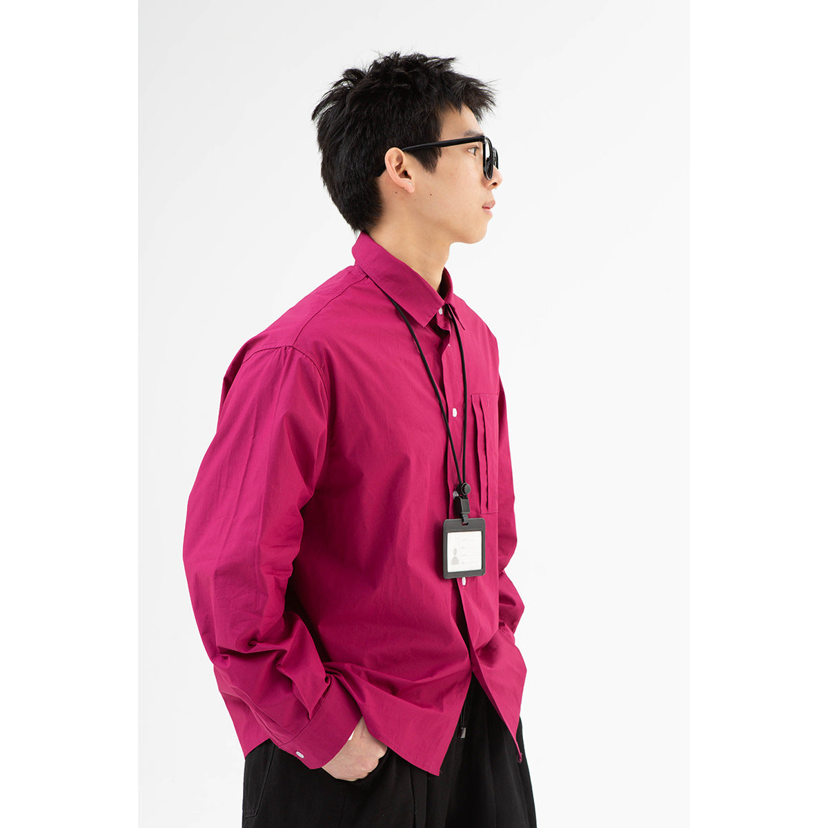 Model in a bright magenta button-up shirt with a chest pocket and black lanyard, shown in side profile.