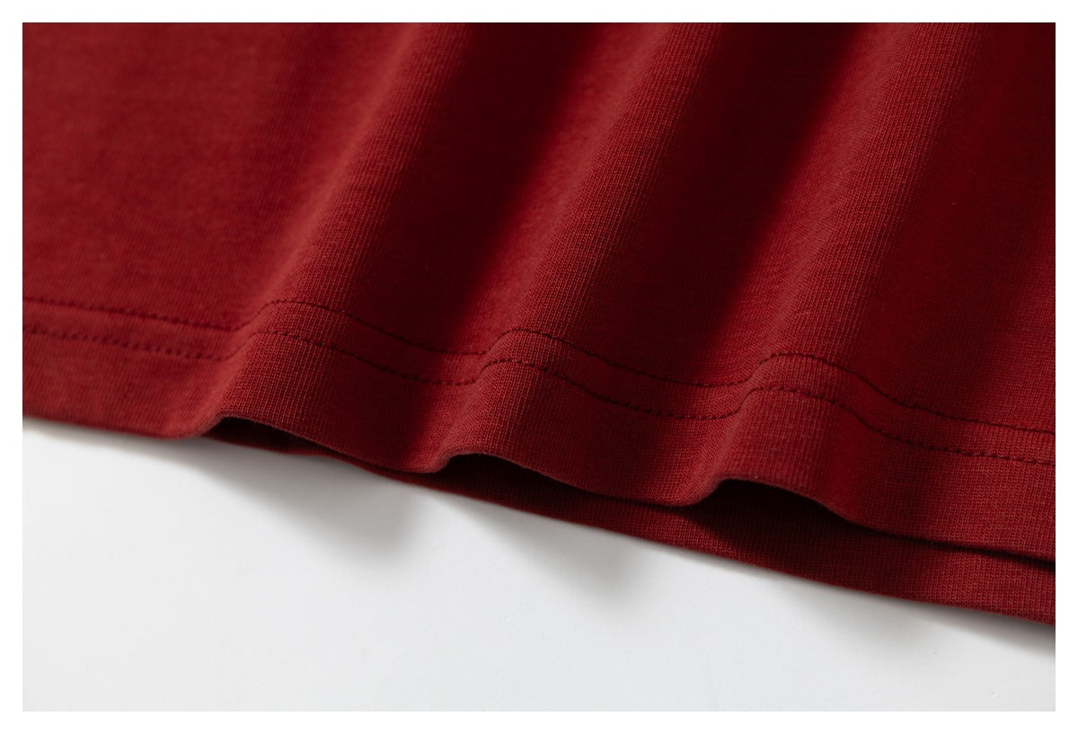 Close-up of the stitched hem on deep red fabric, with the edge slightly rippled.