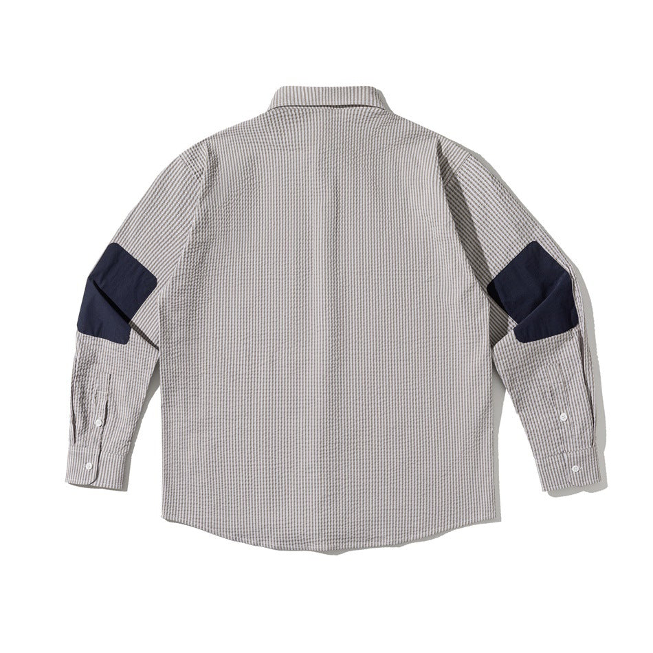 Back view of gray and white striped long-sleeve shirt with navy patches on the sleeves at the elbows