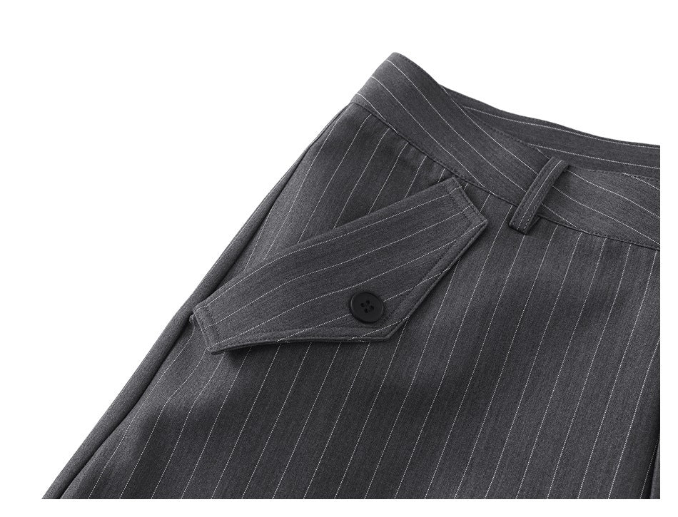 Angled close-up of charcoal pinstripe trousers showing a buttoned pocket flap and belt loop.
