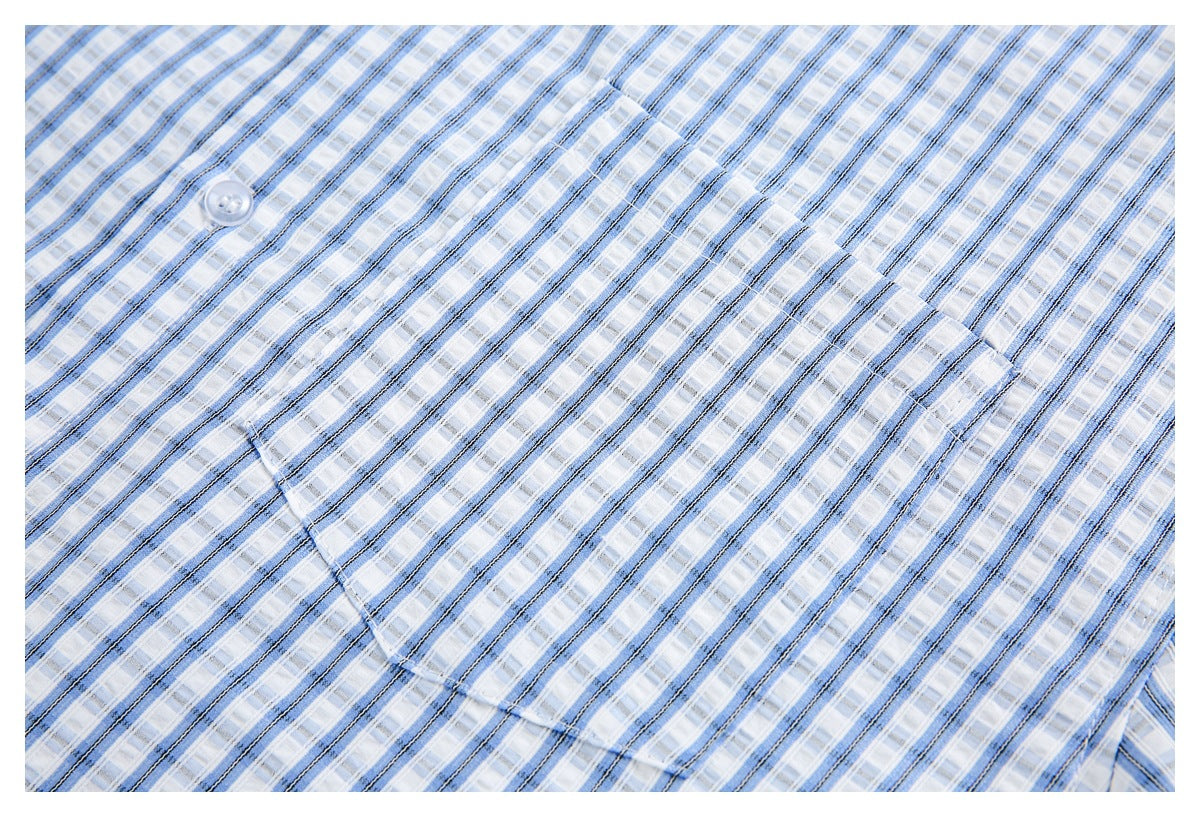 Close-up of the blue plaid shirt front, showing a single chest pocket and a translucent button.