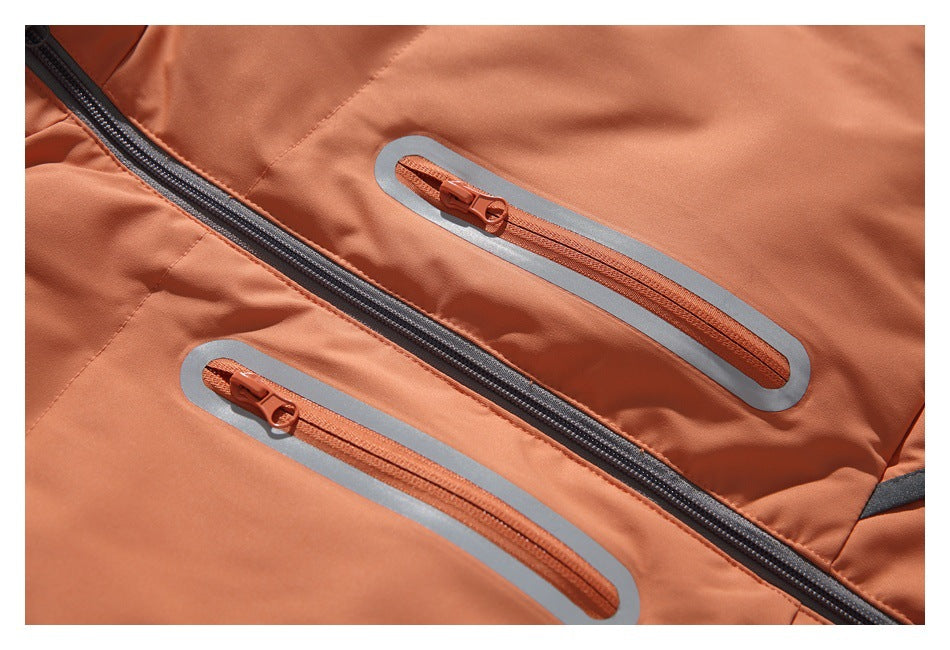 Close-up of two orange zip pockets with gray trim beside the vest's dark front zipper.