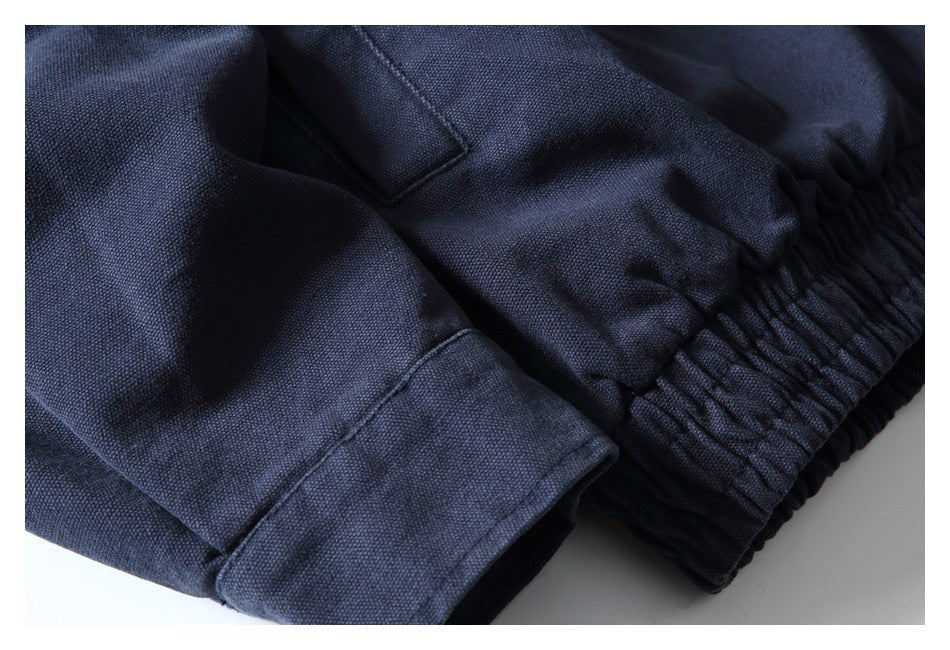 Close-up of dark navy garment fabric showing a stitched cuff beside a gathered elastic waistband.