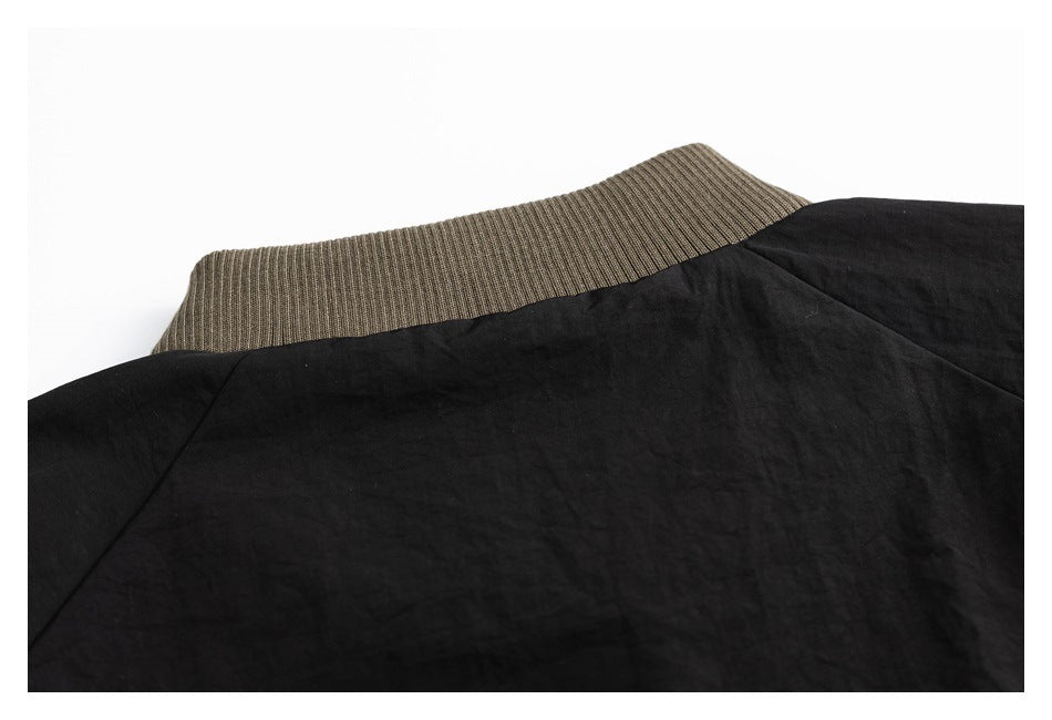 Close-up of a black jacket's back collar with olive-brown ribbed trim.