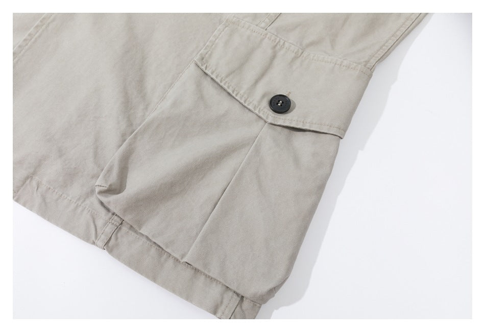Close-up of a beige garment pocket flap with a dark button and visible stitching.