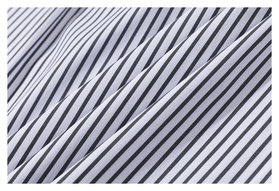Close-up of white fabric with narrow black stripes draped in soft folds.