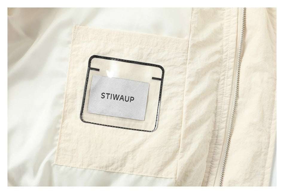 Interior view of a cream garment showing a stitched pocket, zipper, and a fabric brand label.