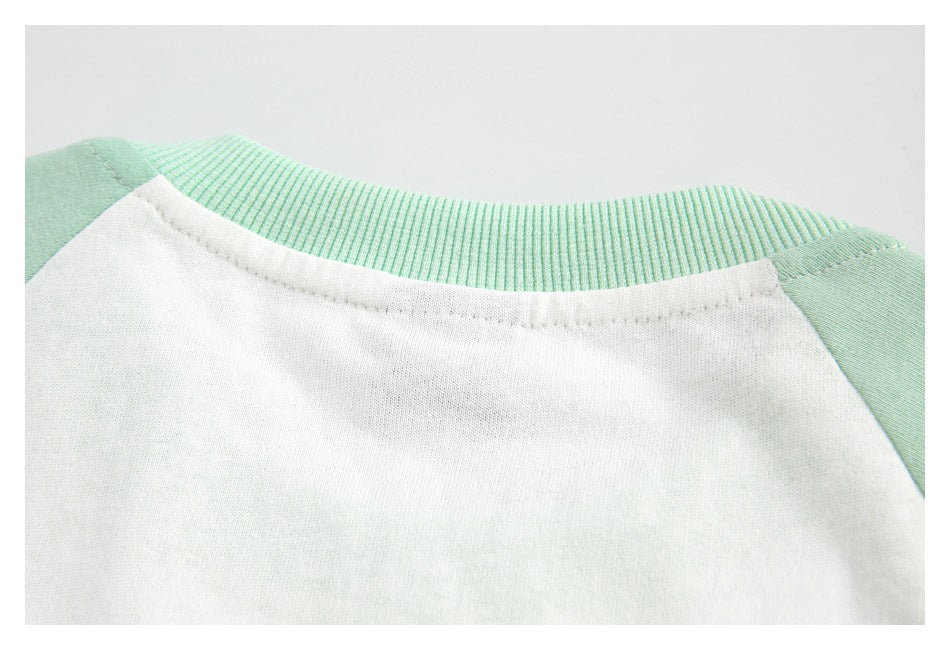 Close-up of the back neckline of a white raglan shirt with mint sleeves and a ribbed collar.