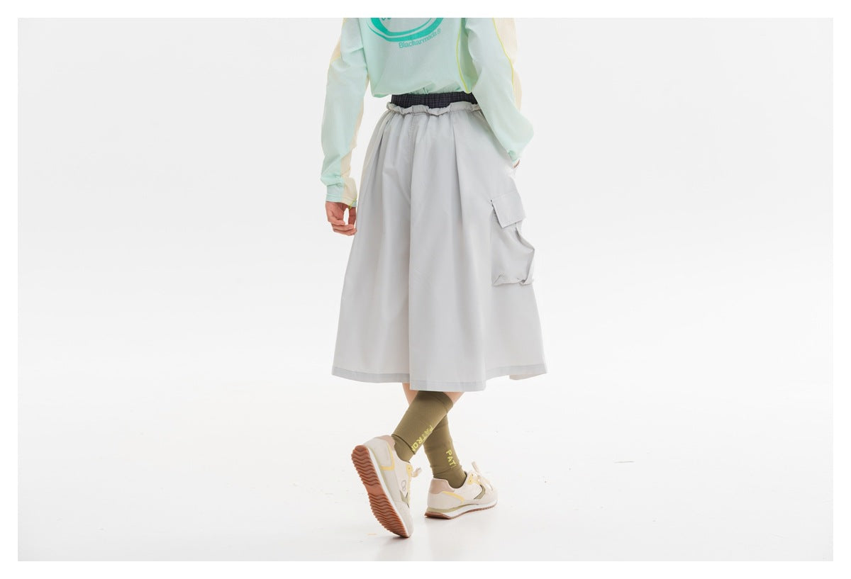Cropped rear view of a model wearing a light gray cargo midi skirt with a large side pocket.
