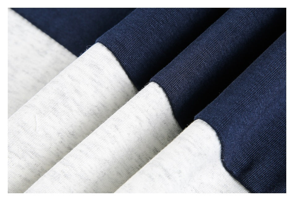 Close-up of folded light gray and dark navy garment sections, showing their contrasting fabric and edges.