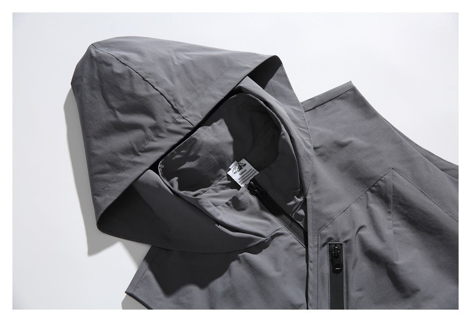 Close-up of a gray hooded vest showing the hood, inner label, and black front zipper.