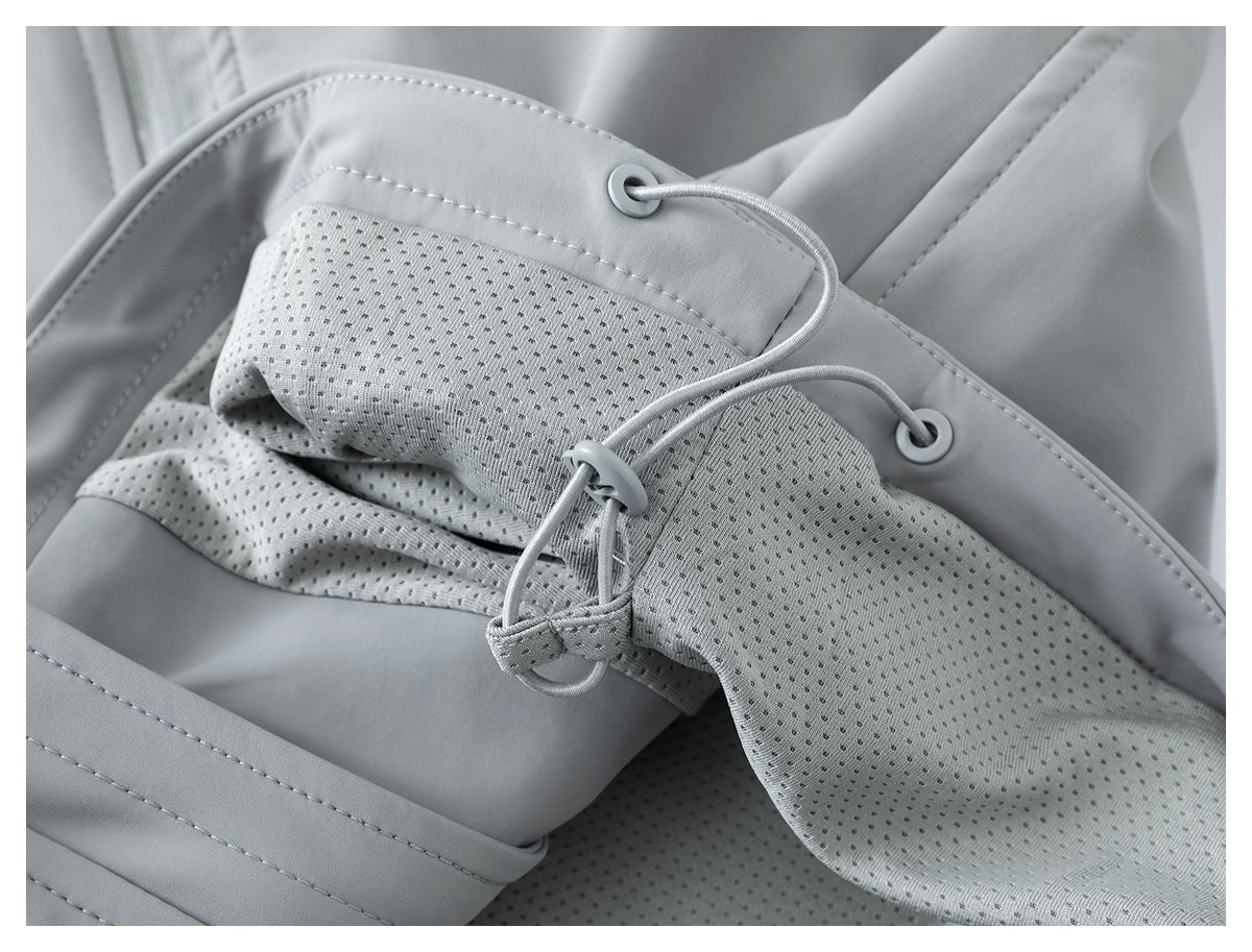 Close-up of a light gray hood with perforated lining, eyelets, and an adjustable drawcord.