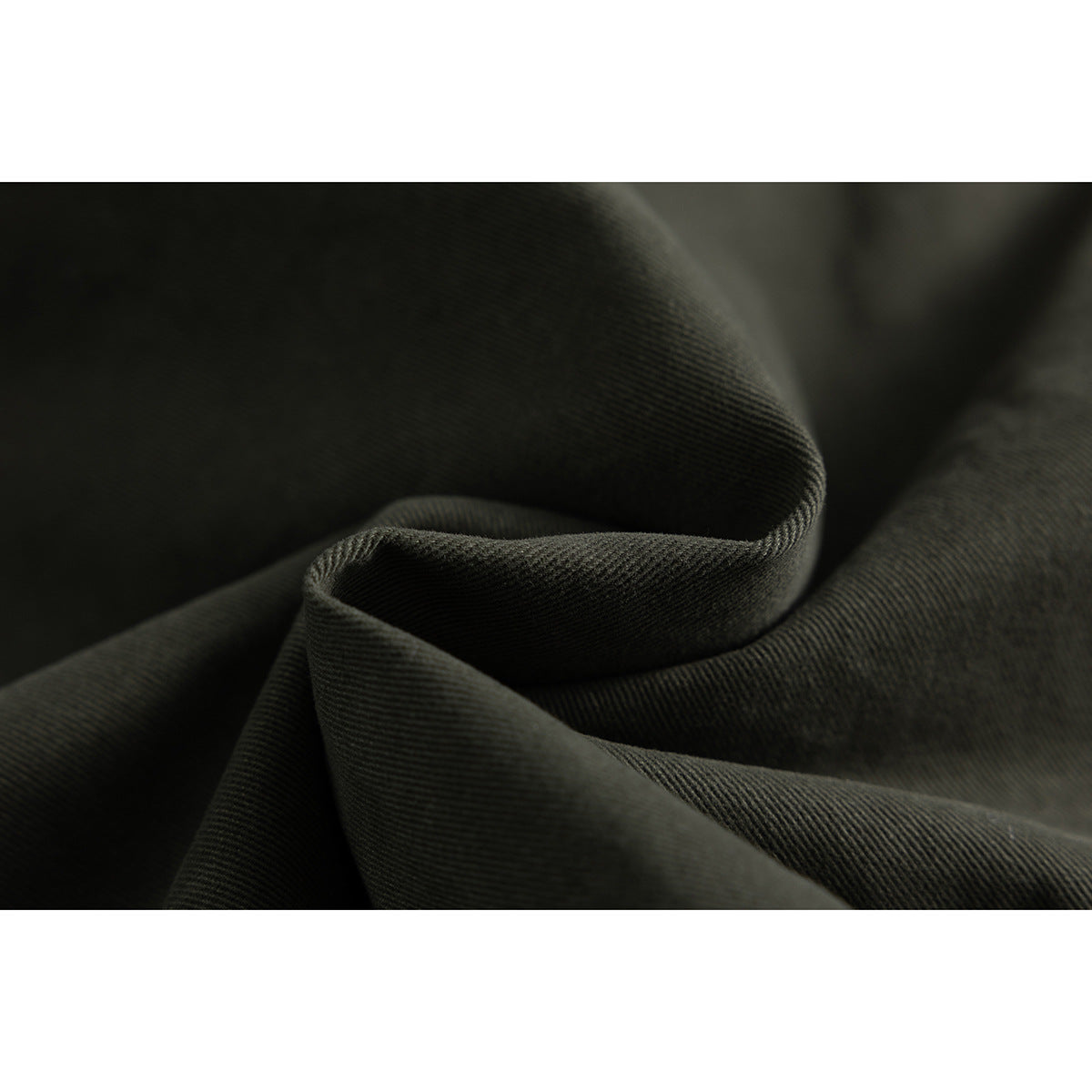 Macro view of dark olive jacket fabric folded to show its diagonal weave.