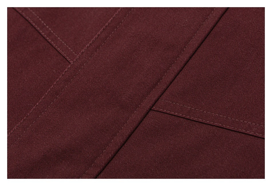 Close-up of deep burgundy jacket fabric, seams, and topstitched panels.