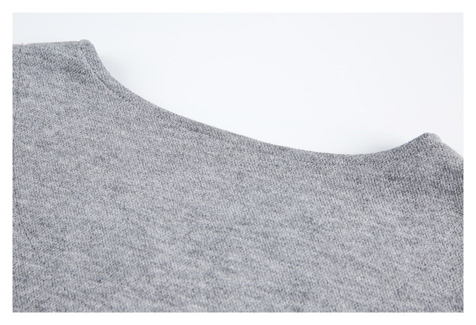 Close-up of a heather gray knit garment showing a curved neckline edge and fine textured stitches.