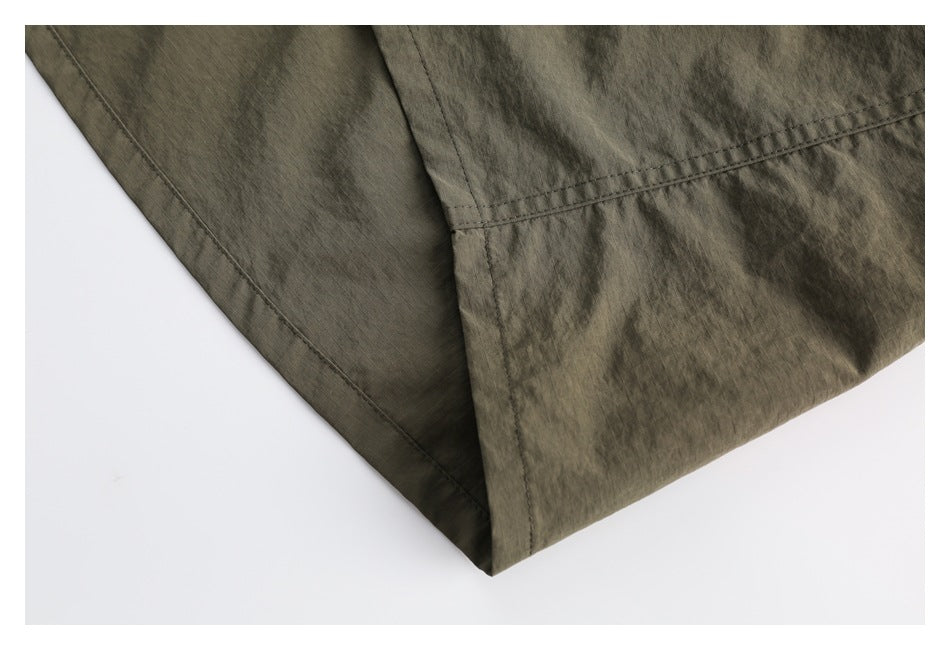 Close-up of the olive skirt hem and stitched seams against a white background.