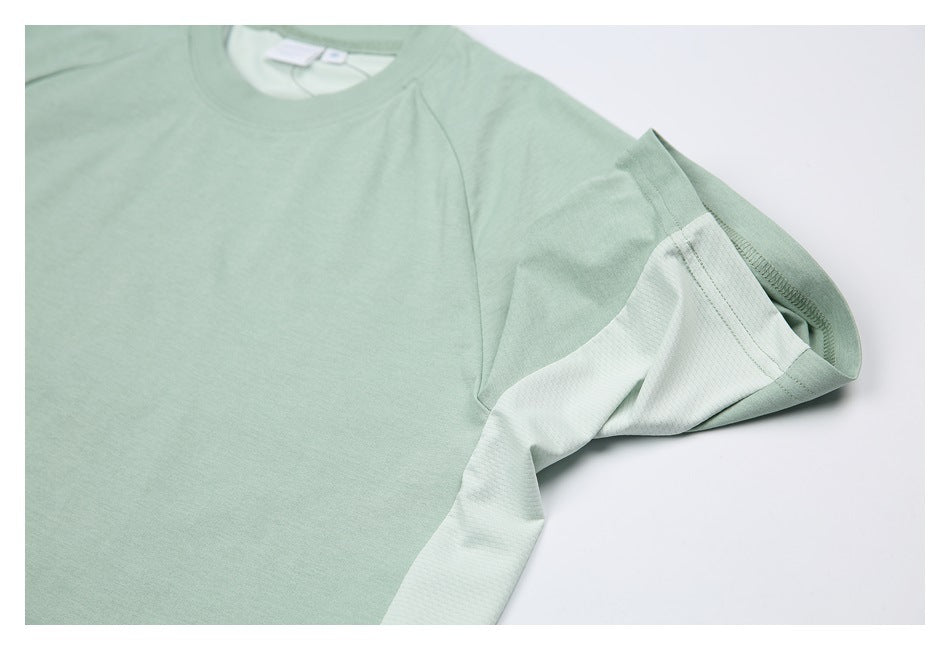 Close-up of a pale sage-green shirt showing the crew neckline and lighter mesh-textured sleeve panel.