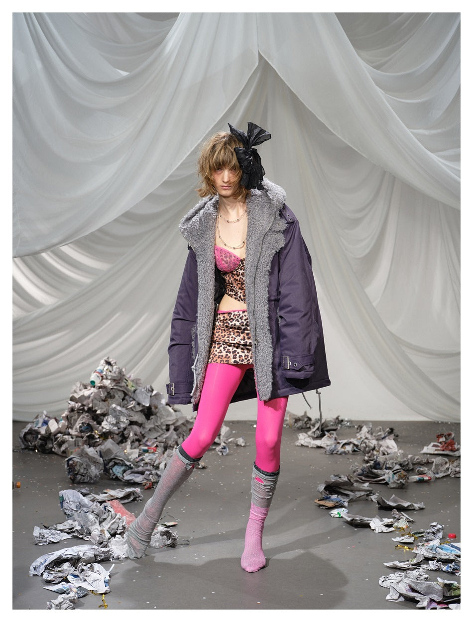 Model in a plum parka with a wide gray textured collar, leopard-print separates, and bright pink tights.
