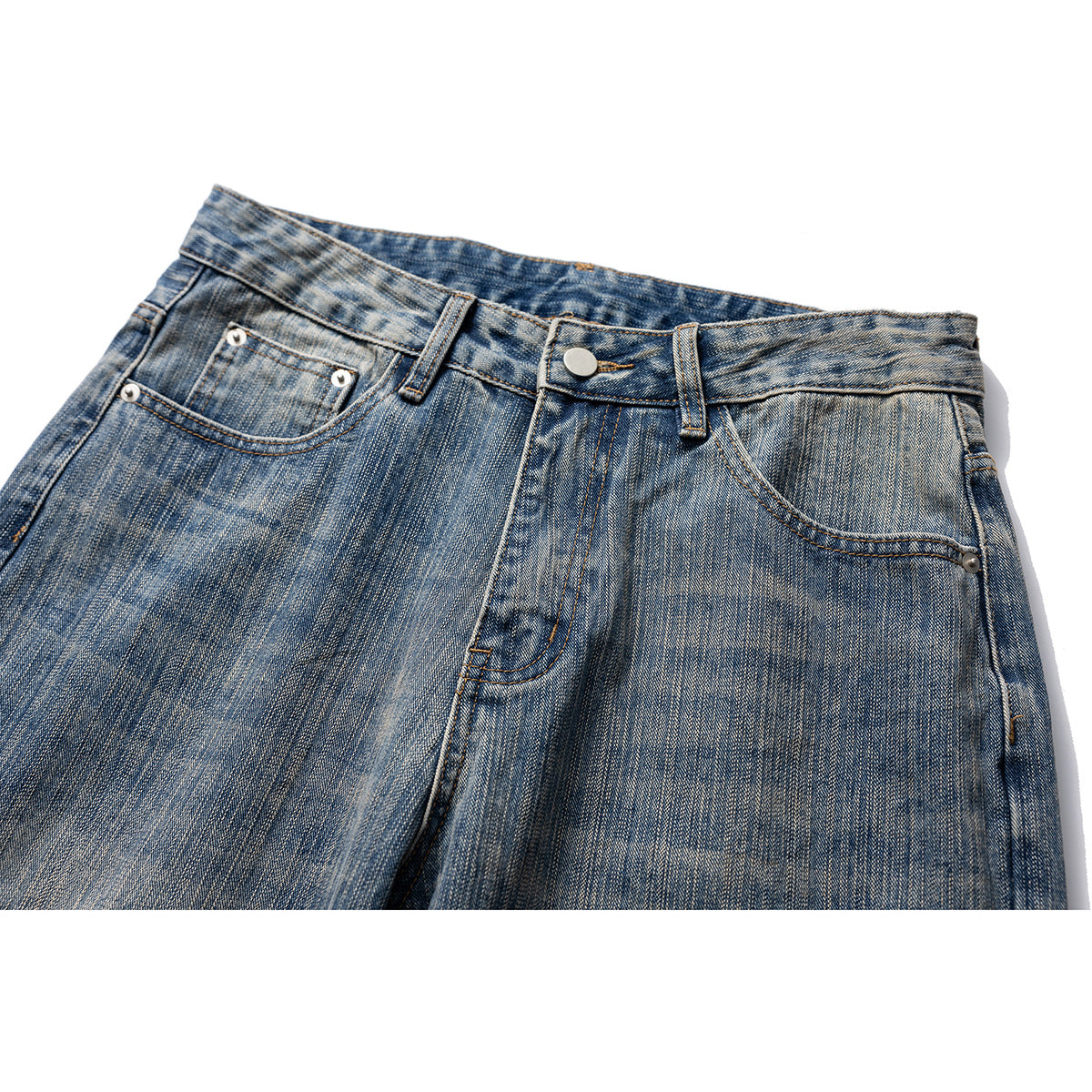 Close-up front view of blue faded jeans showing the waistband, button, fly and front pockets.