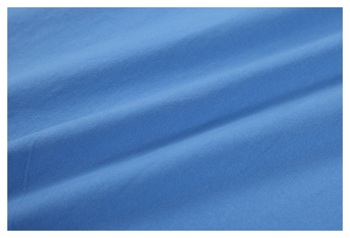 Macro view of blue garment fabric gathered into soft folds, showing its surface texture.