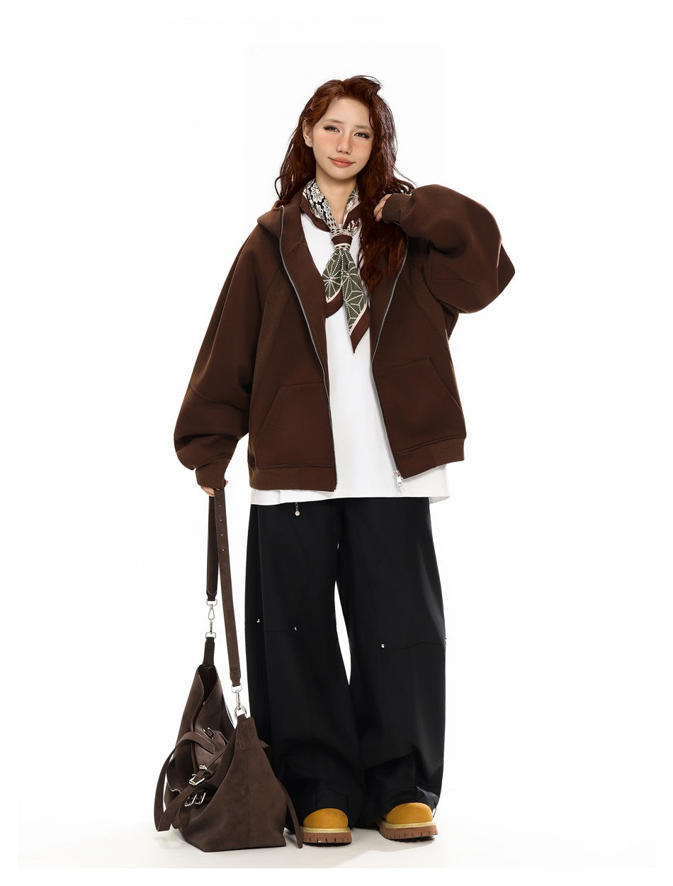 Model wearing an open dark brown zip-up hooded jacket with oversized sleeves and front pockets.