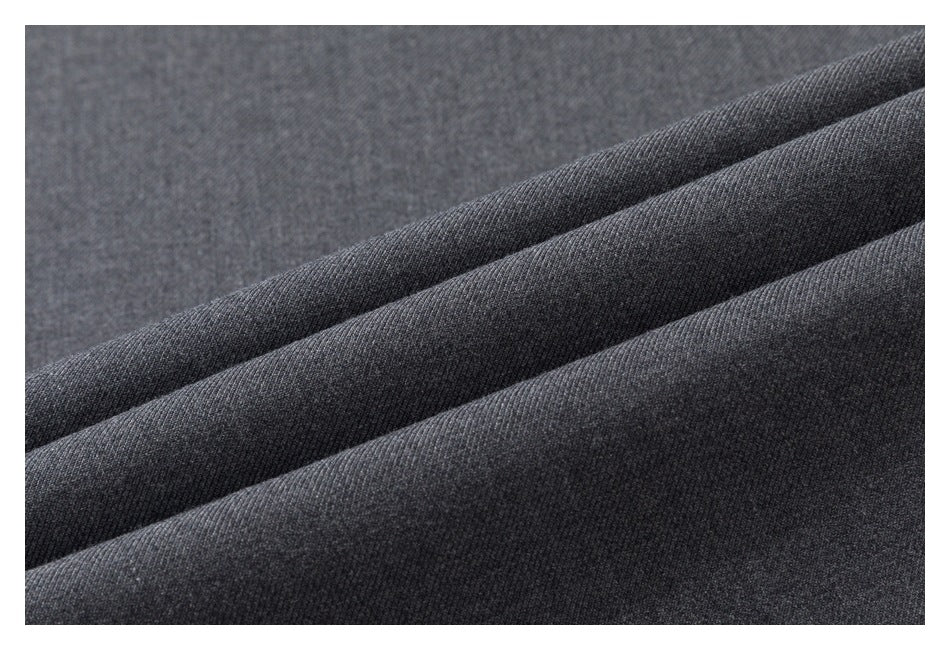 Close-up of dark charcoal gray fabric arranged in soft diagonal folds, showing a fine knit texture.