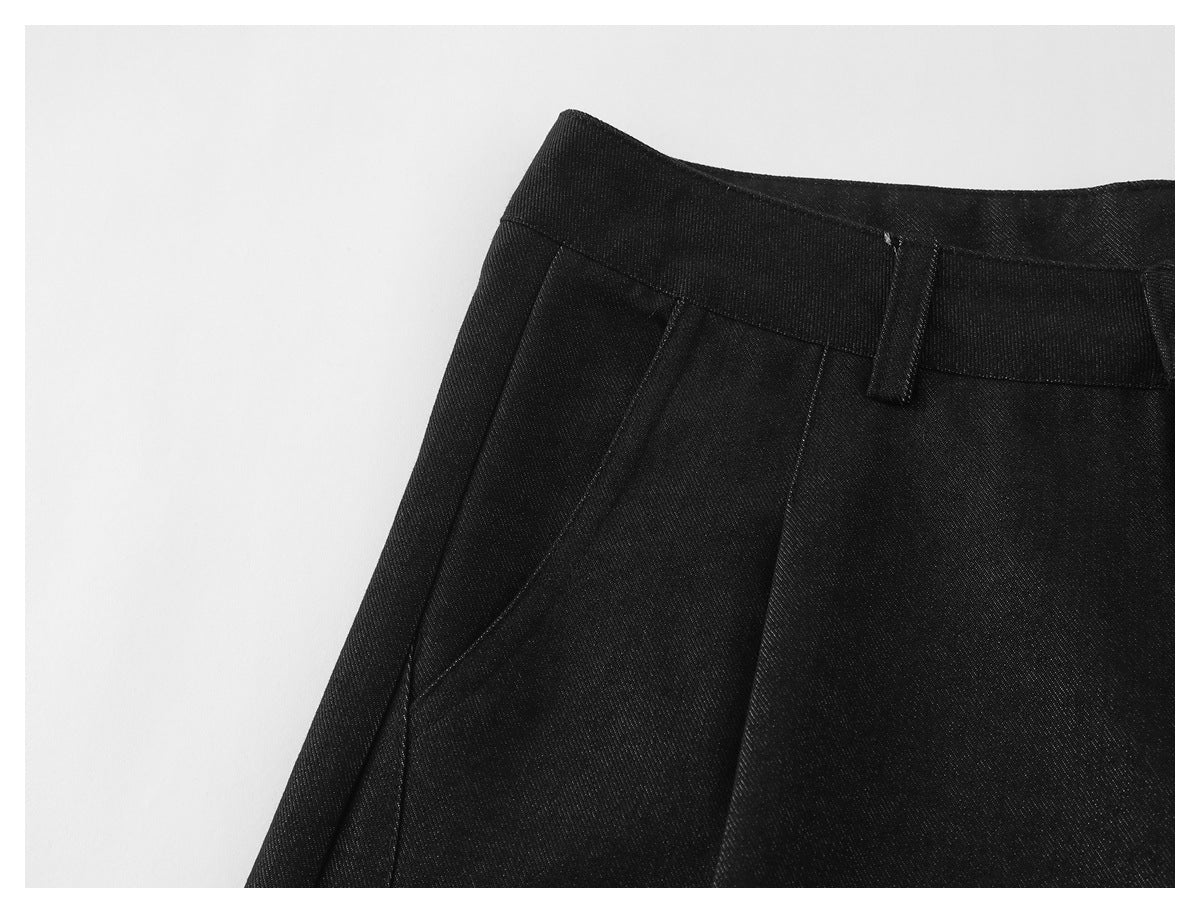 Close-up of black trousers showing a belt loop and angled front pocket seam.