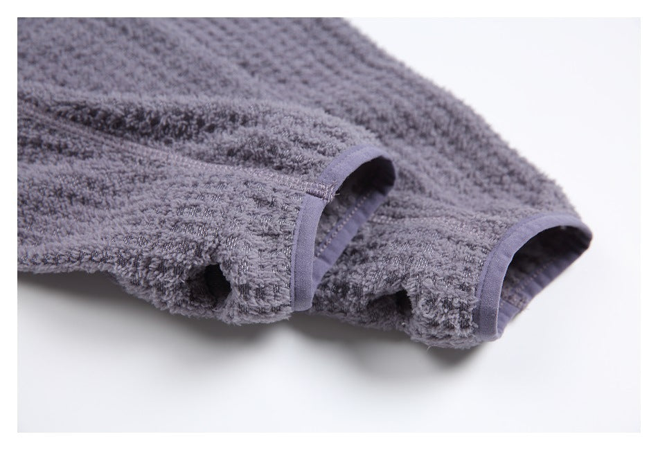 Close-up of two openings with purple-gray binding on the gray textured garment.