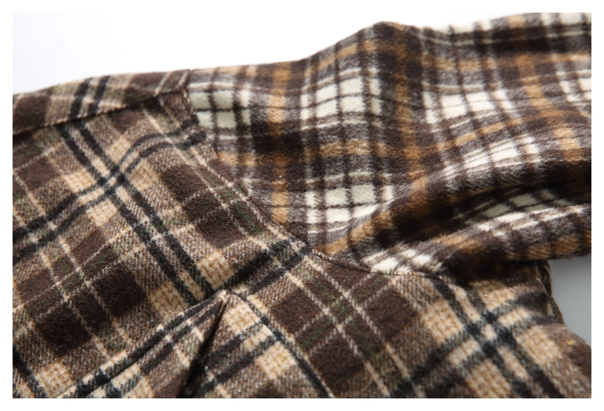 Close-up of a brown plaid shirt showing a folded seam and overlapping fabric panels.
