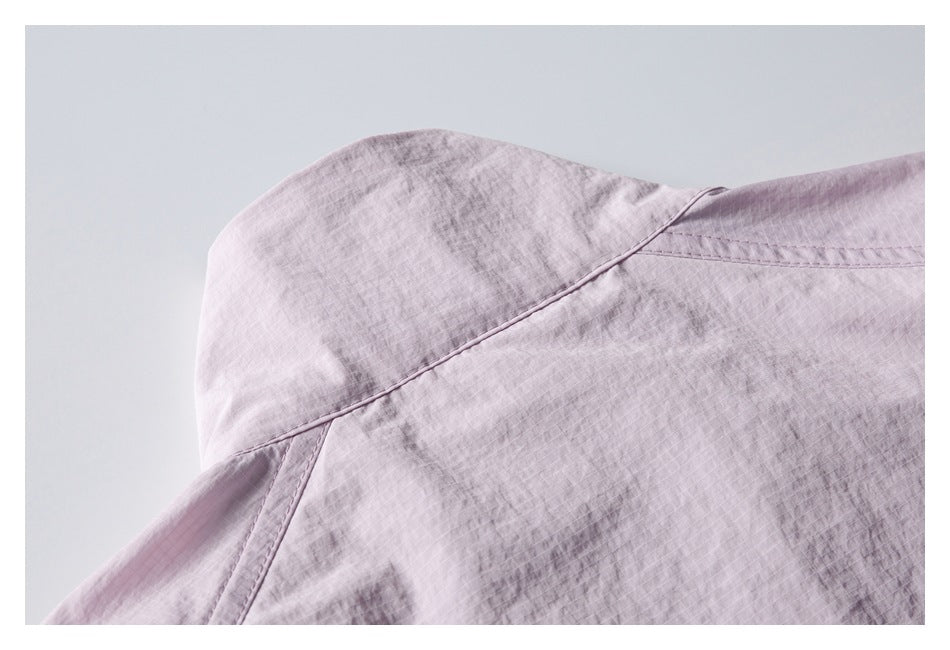 Close-up of the shoulder seam and collar area of a pale pink garment.