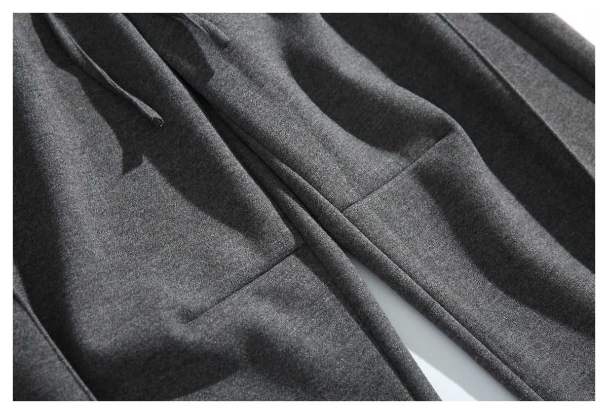 Close-up of dark gray pant legs and a stitched pocket seam.