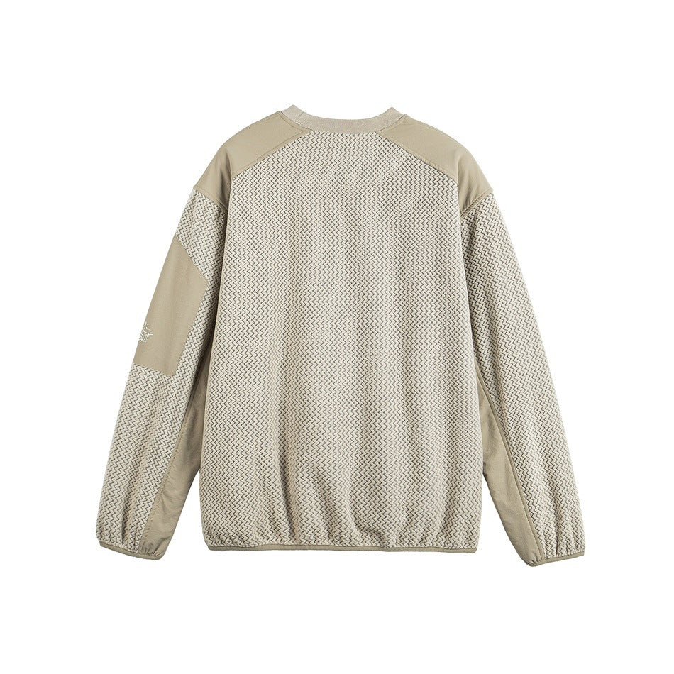 Back view of a beige long-sleeve pullover with a cream-and-dark zigzag body, solid shoulder panels, and a small sleeve