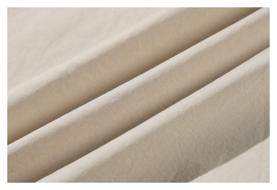 Close-up of beige garment fabric arranged in soft folds.