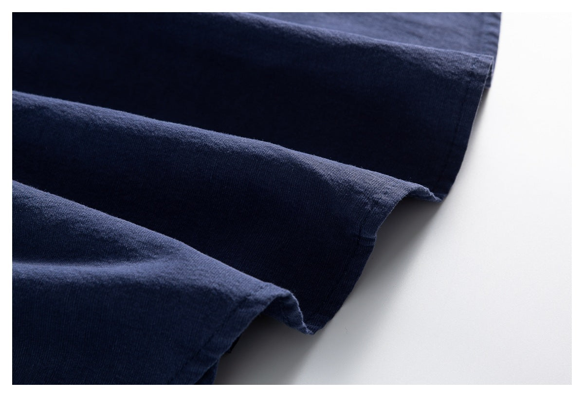Close-up of dark navy fabric folded into layers, showing the edge and surface texture.