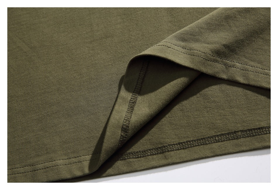 Close-up of the olive green T-shirt's sleeve hem and stitched edge.