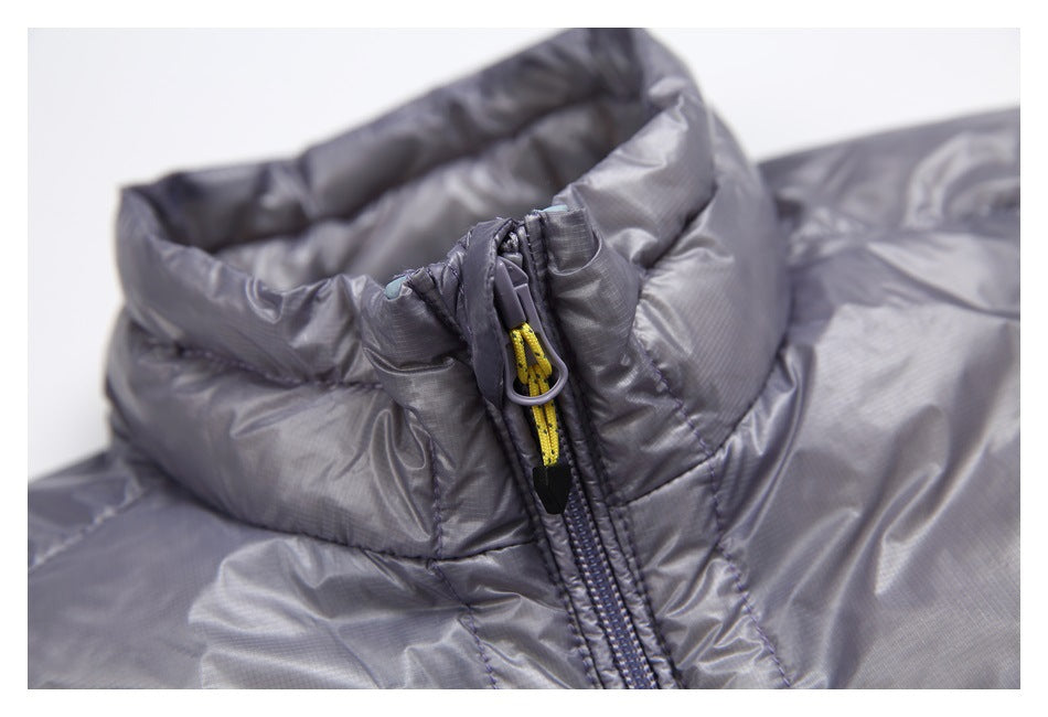 Close-up of a gray quilted jacket's raised collar and zipper with a yellow cord pull.