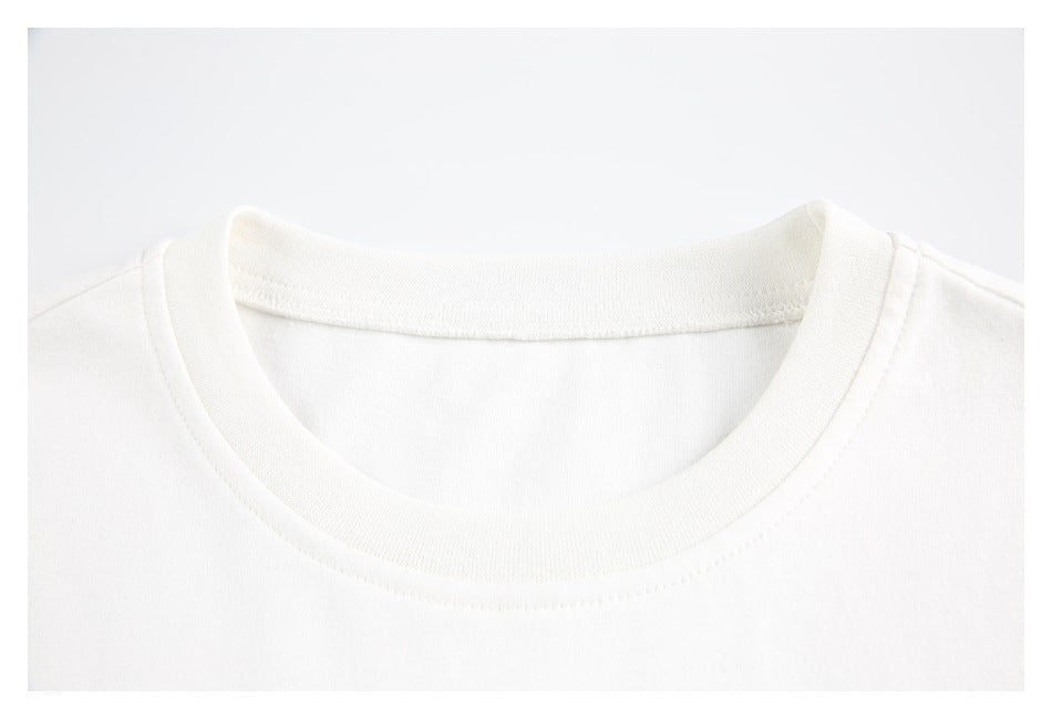 Close-up of the white T-shirt's ribbed crew neckline and collar stitching.