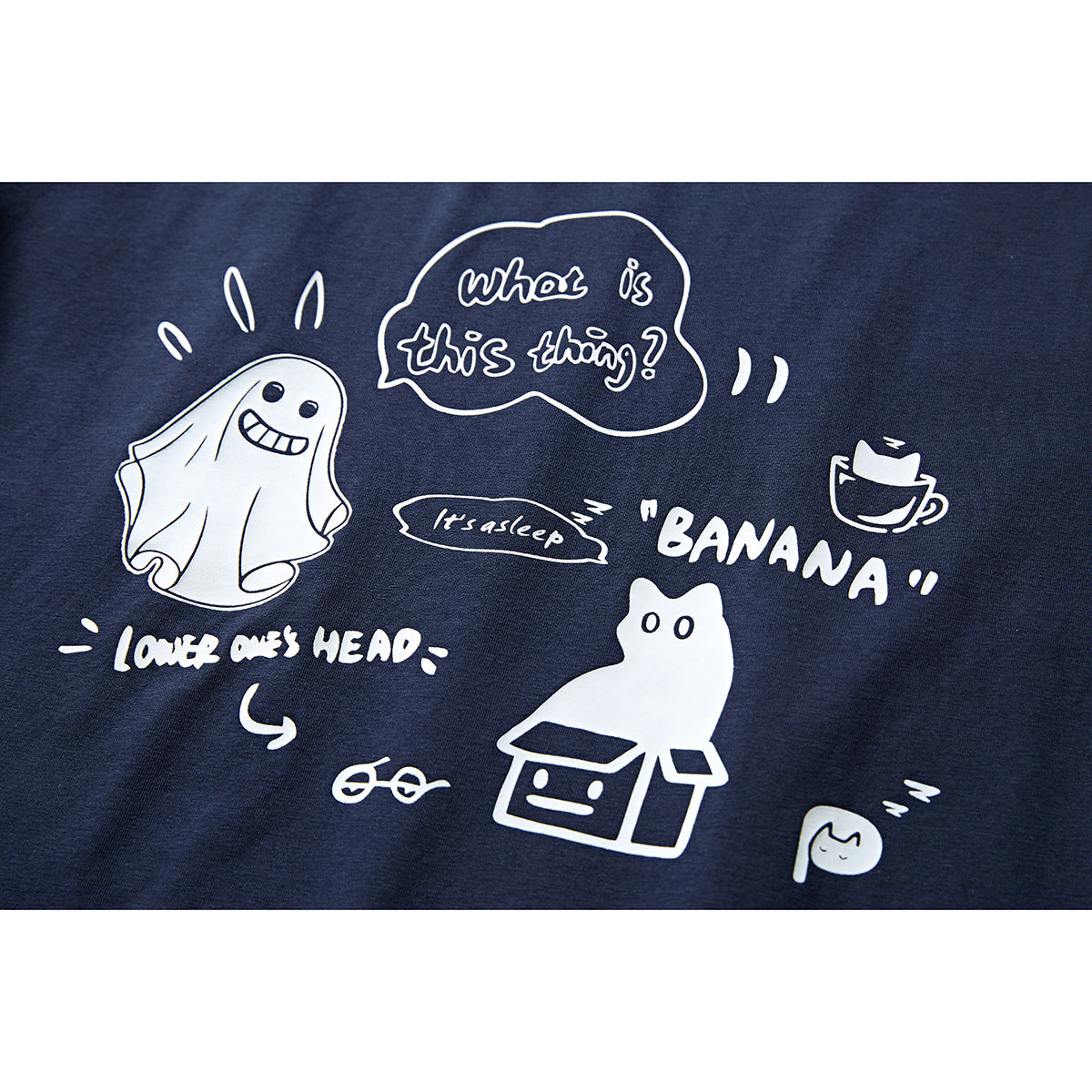 Close-up of a navy T-shirt's white cartoon and English text print.